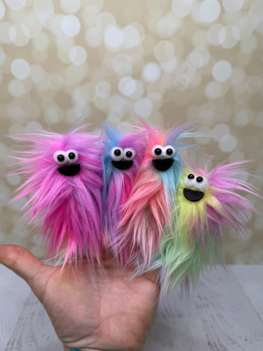 Colorful fuzzy toy held in a hand against a blurred background